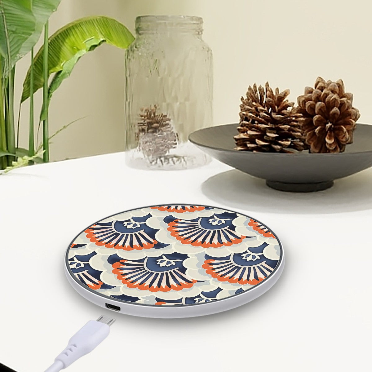 Decorative wireless charging pad with floral pattern on a table with decorative items.
