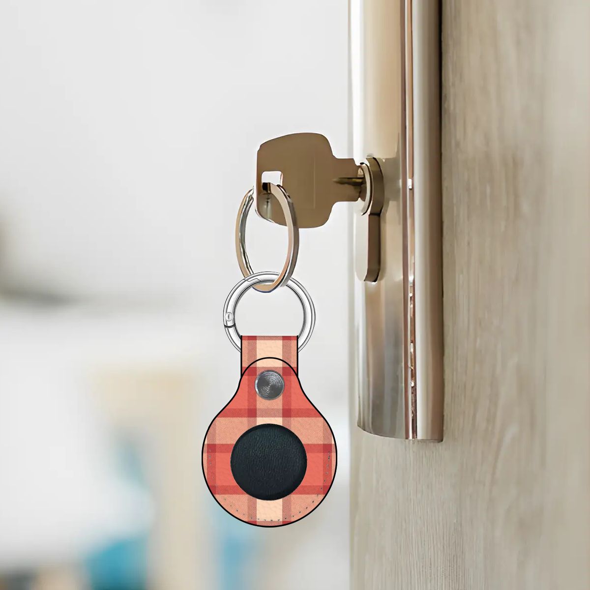 Keychain with a red and black pattern attached to a door handle.