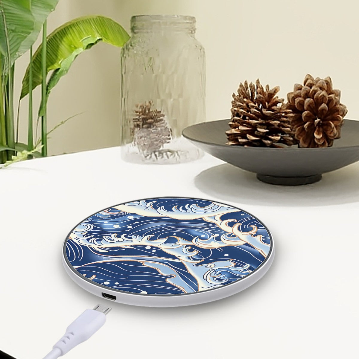 Wireless charging pad with blue wave design on a white surface with decorative items | Casenari