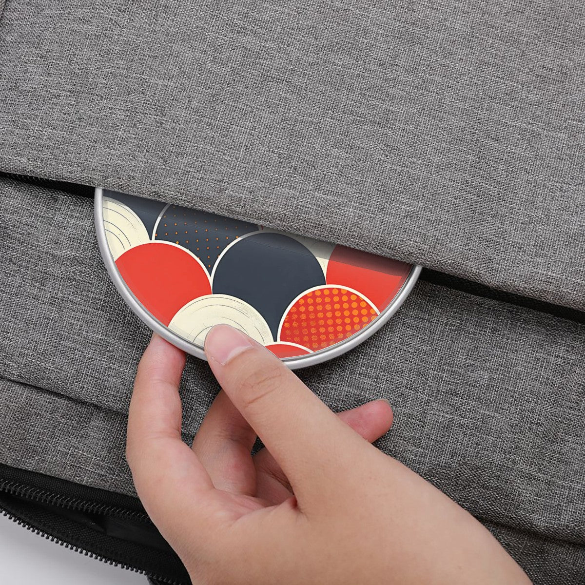 Hand placing a decorative metal object on a gray textured surface