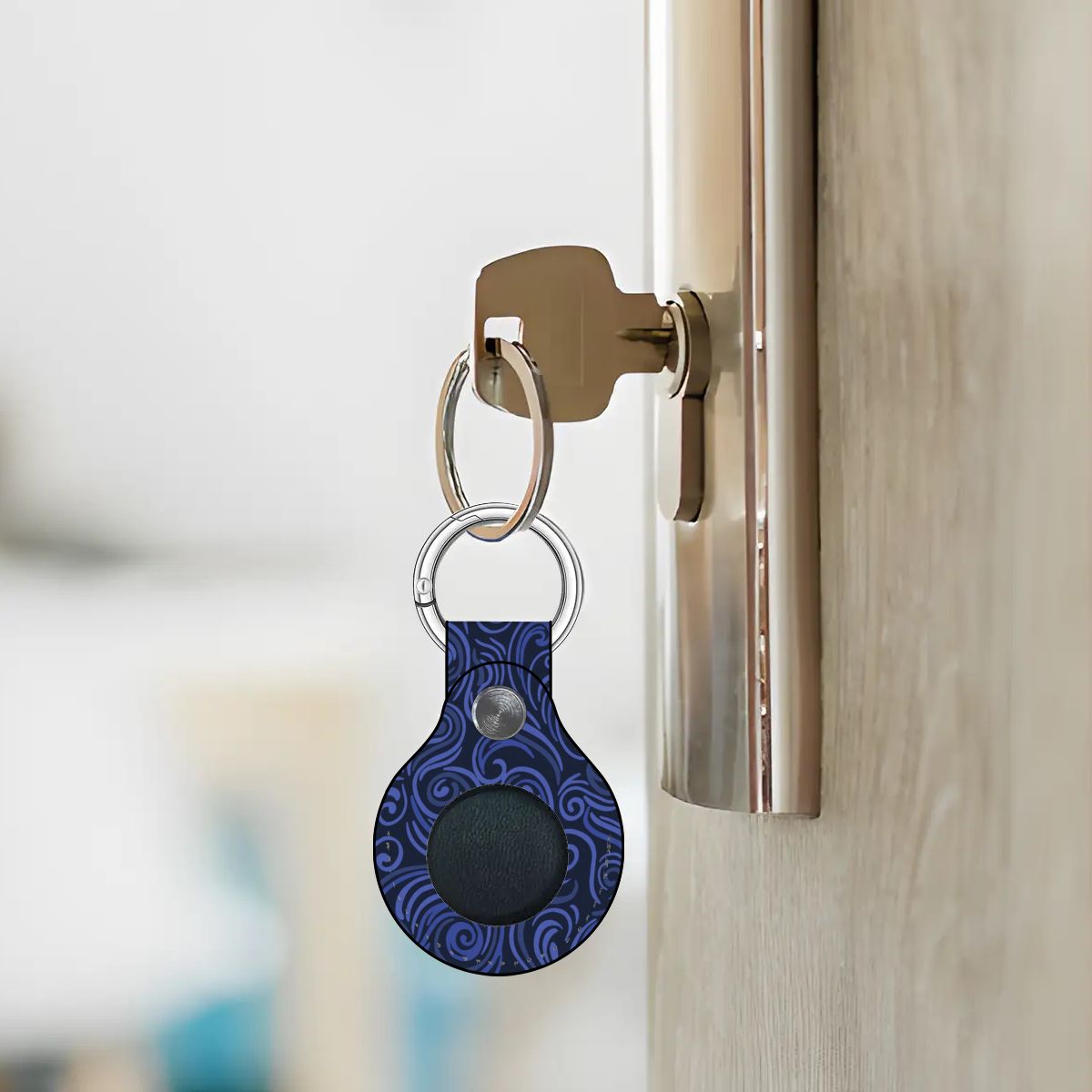 Blue patterned keychain attached to a door handle with a blurred background