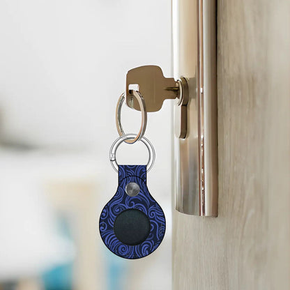 Blue patterned keychain attached to a door handle with a blurred background