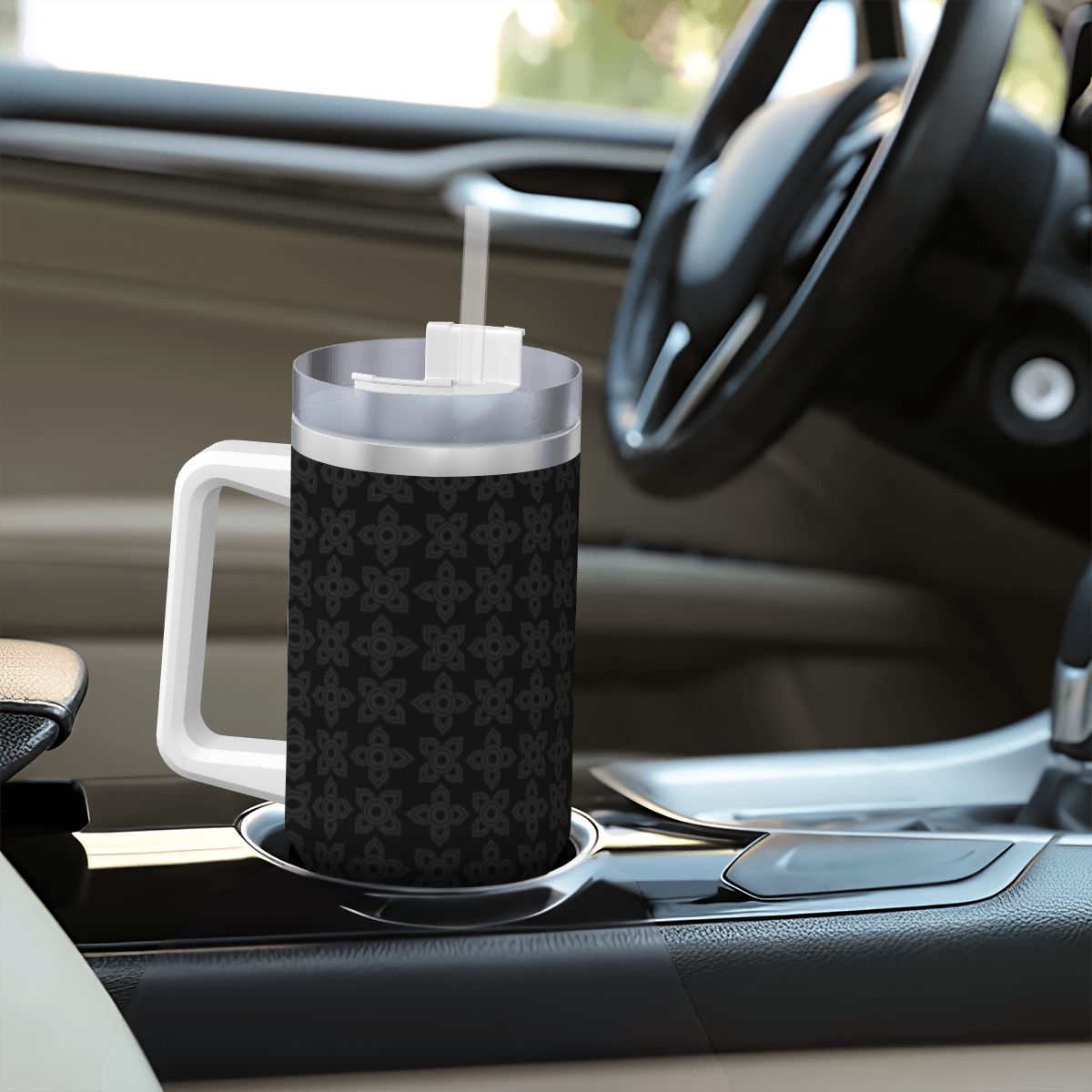 Black patterned mug with a white handle on a car dashboard
