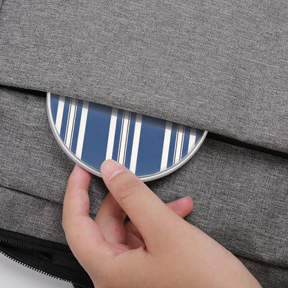 Hand placing a blue and white striped object into a gray fabric bag