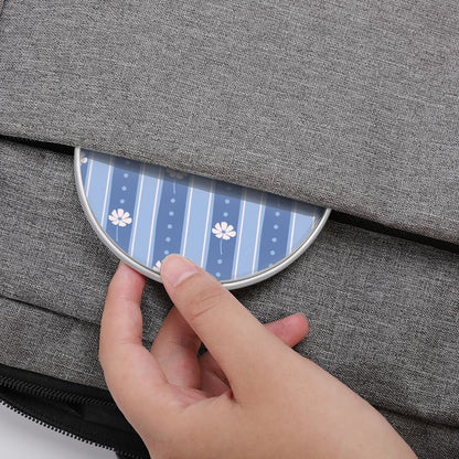 Hand opening a gray textured bag with a blue and white patterned flap.