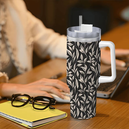 Tropical patterned tumbler on a desk with a person using a laptop in the background