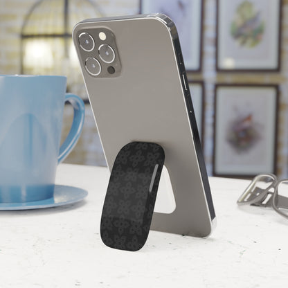 Phone stand with smartphone on a table next to a blue mug
