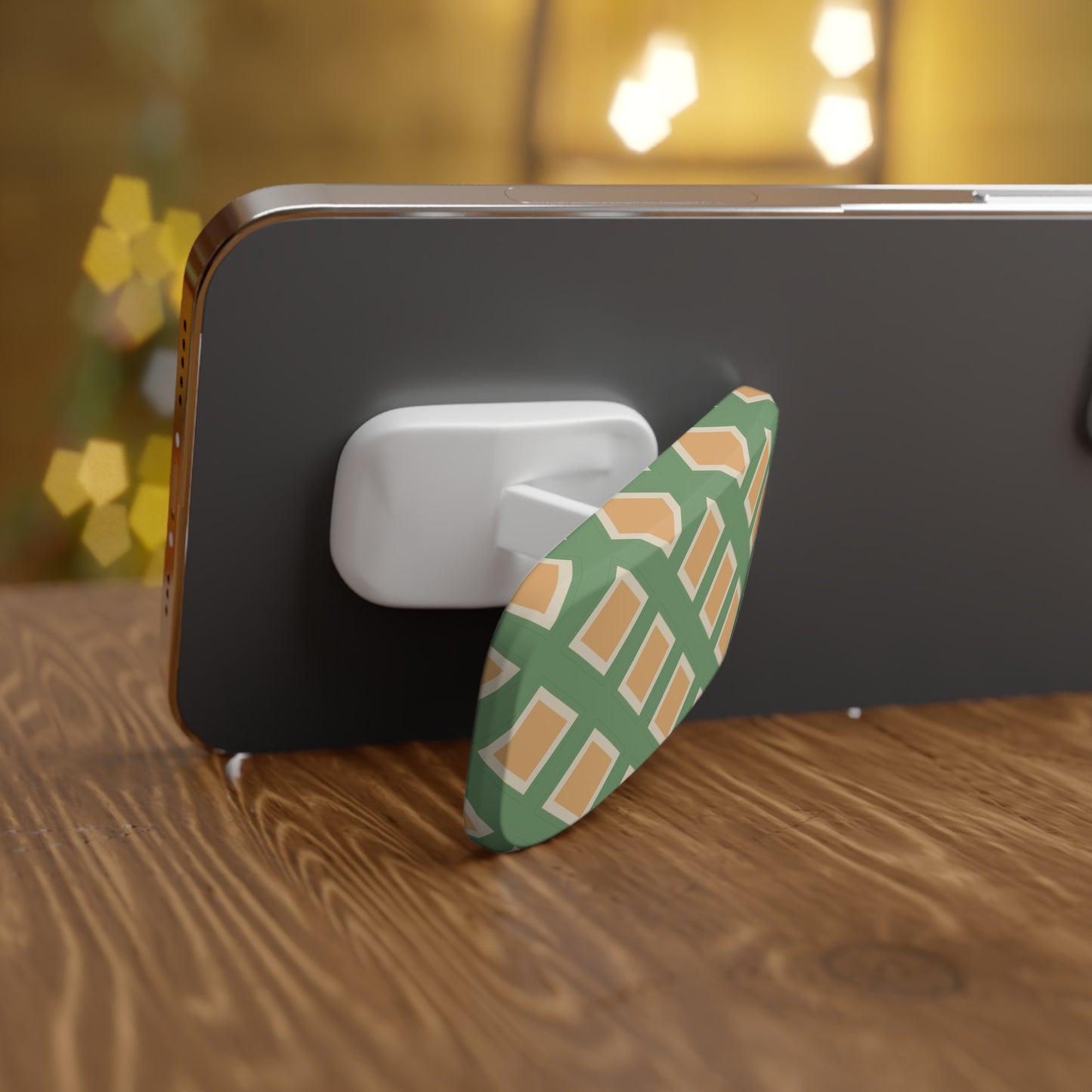 Phone grip with green and brown pattern on a wooden surface