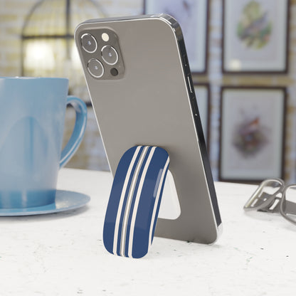 Phone with a blue and white striped stand on a table next to a blue mug.