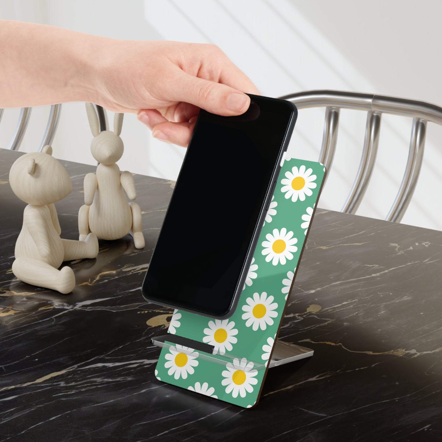 Phone stand with daisy pattern on a marble surface