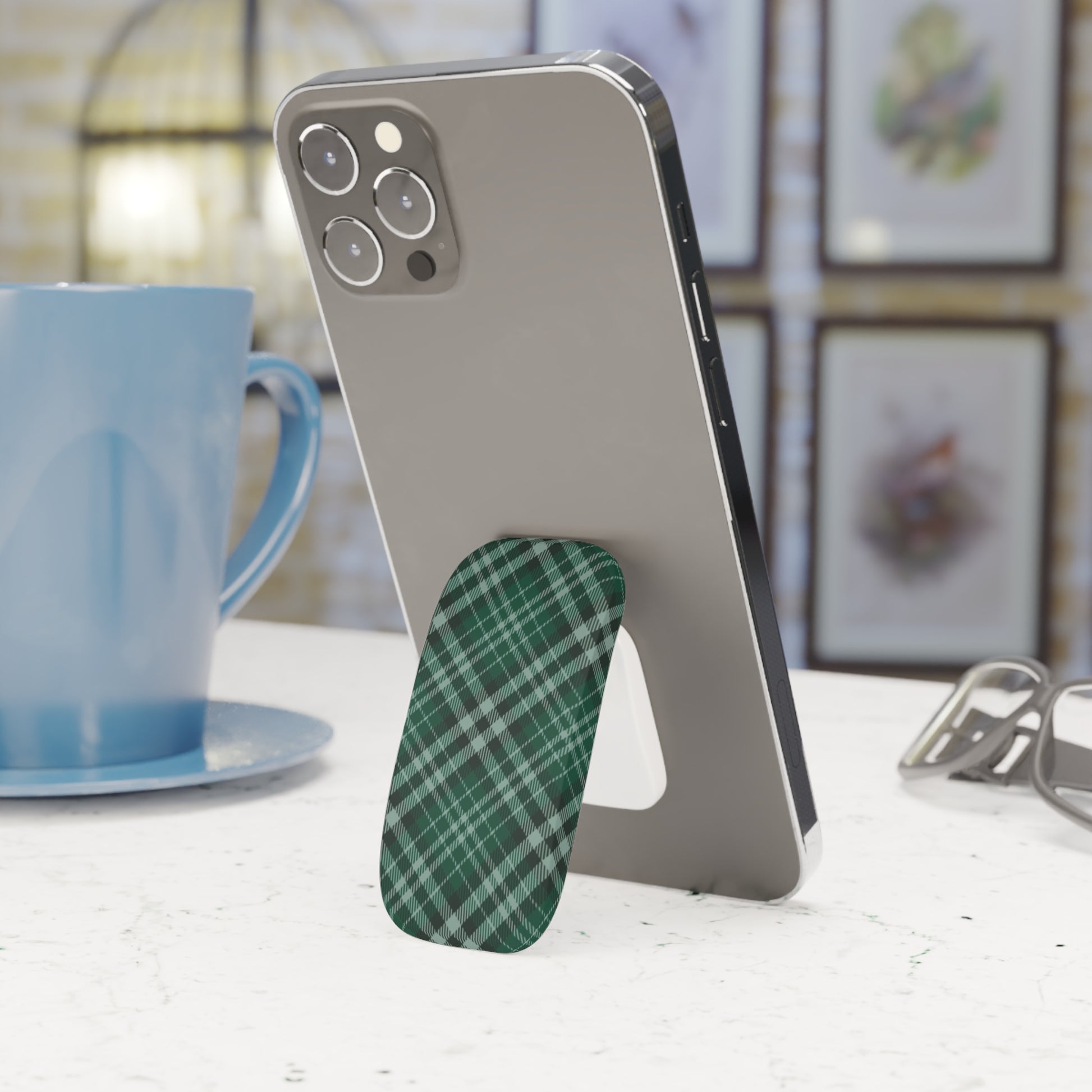 Phone with a green plaid stand on a table next to a blue mug. | Casenari