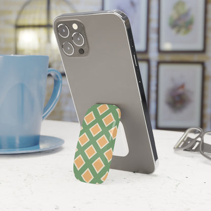 Phone with a pineapple-shaped phone stand on a table with a blue mug in the background
