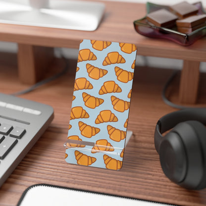 Phone stand with croissant pattern on a desk with keyboard and headphones | Casenari