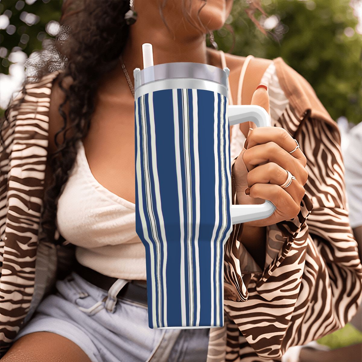 Person holding a blue and white striped mug outdoors