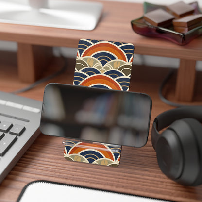 Desk setup with a smartphone on a stand, keyboard, and headphones with decorative coasters.