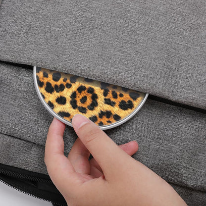 Hand placing a leopard print coin purse into a gray fabric bag.