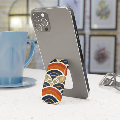 Phone with a colorful stand on a table next to a blue mug