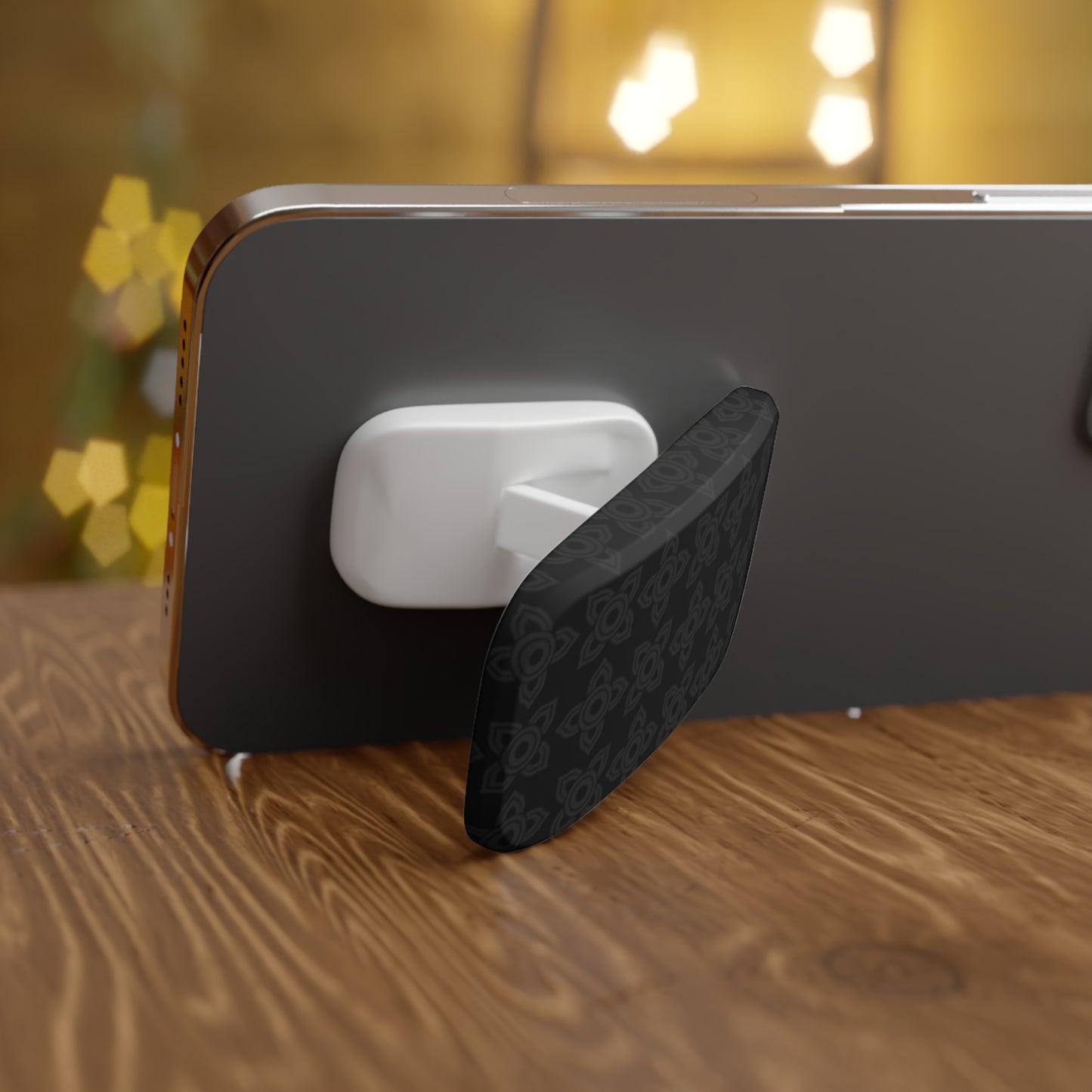 Black phone stand with wireless earbuds on a wooden surface