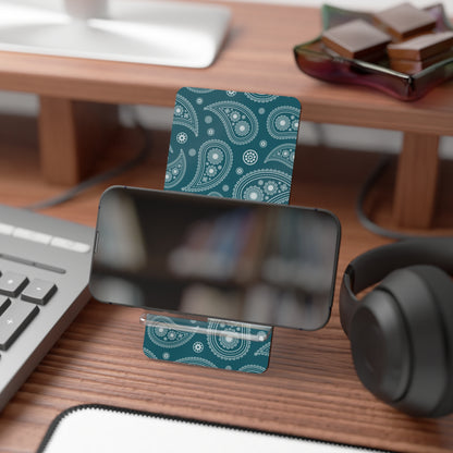 Teal paisley patterned card on a desk with a phone, keyboard, and headphones.