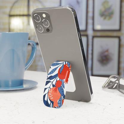 Phone with a floral stand on a table next to a blue mug