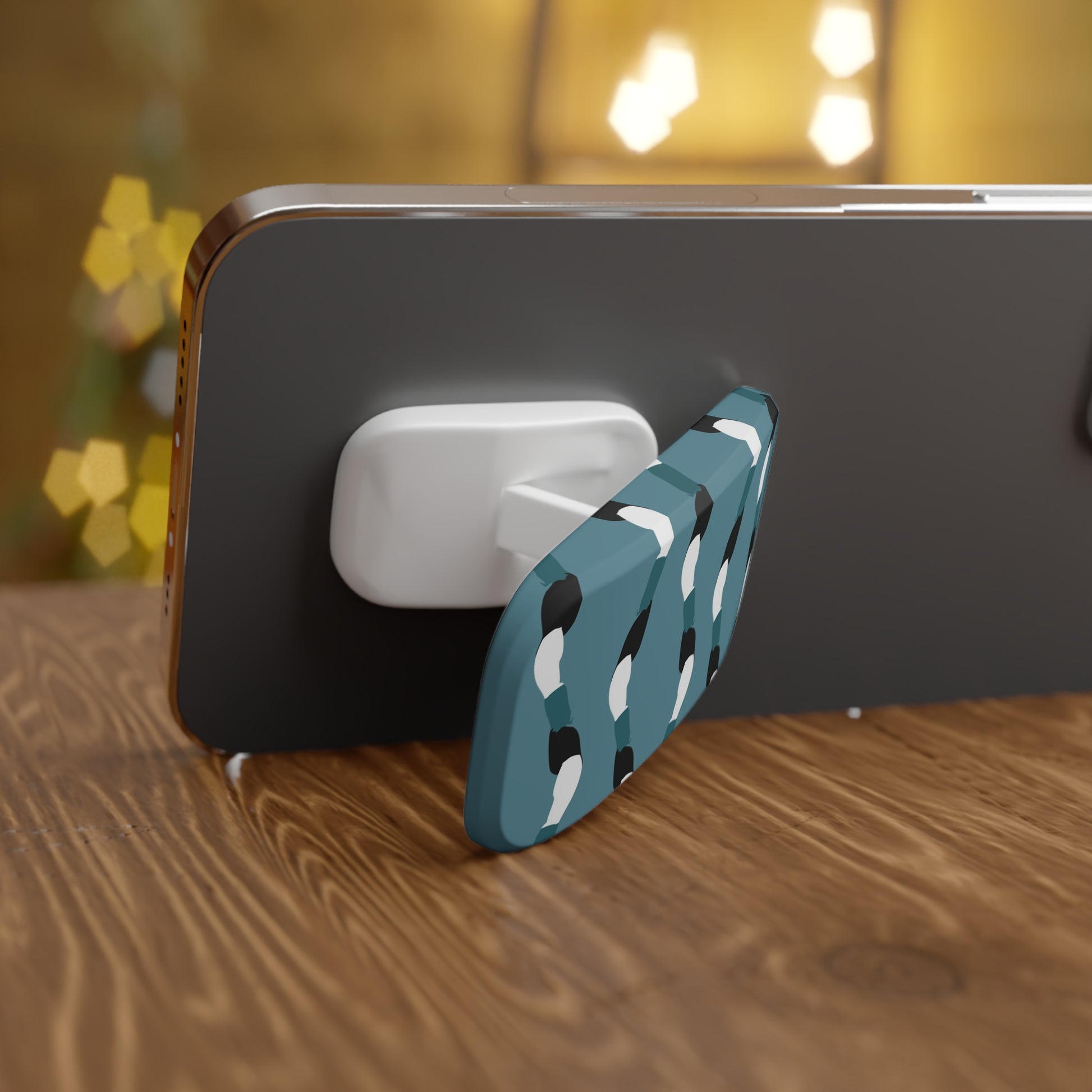 Phone with a blue and white patterned stand on a wooden surface with blurred lights in the background