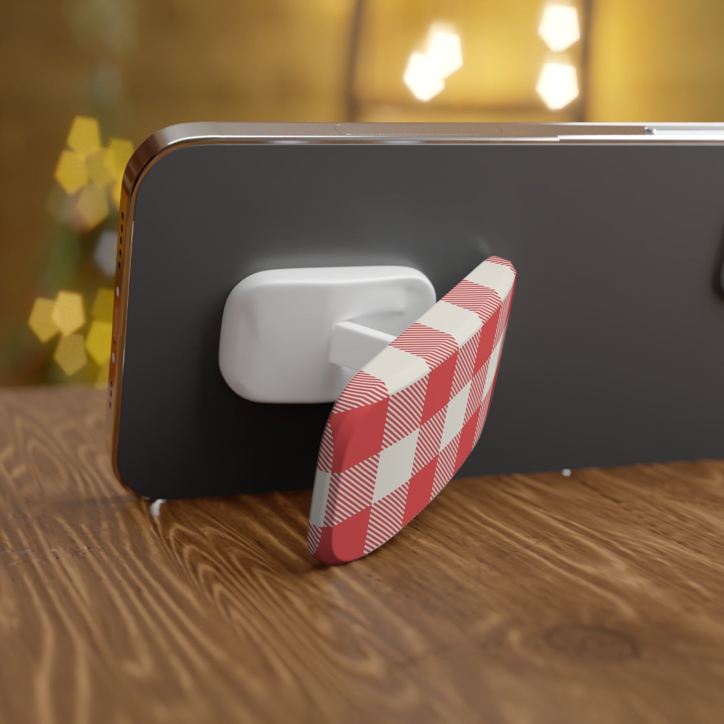 Phone with a red and white checkered stand on a wooden surface