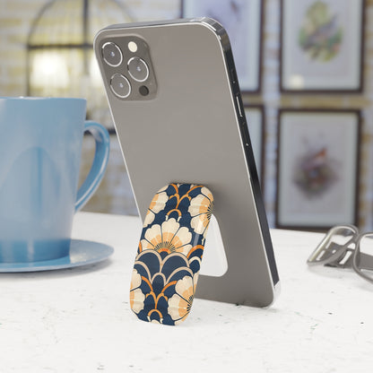 Phone with a floral stand on a table next to a blue mug