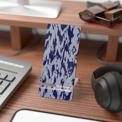 Phone stand with blue abstract pattern on a desk with keyboard, mouse, and headphones.