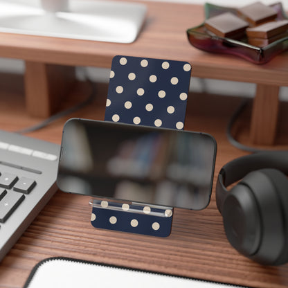 Polka dot phone stand on a desk with a smartphone, keyboard, and headphones.