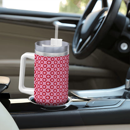 Pink polka dot mug with a straw on a car cup holder