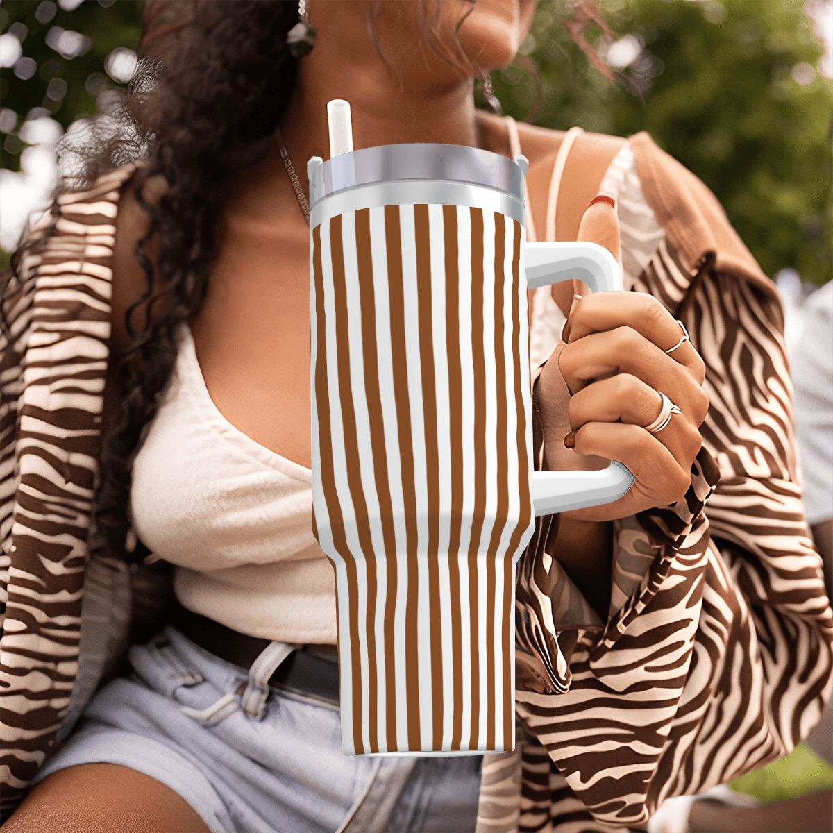 Person holding a striped mug with a blurred background