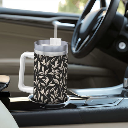 Black and white patterned mug with a straw on a car dashboard