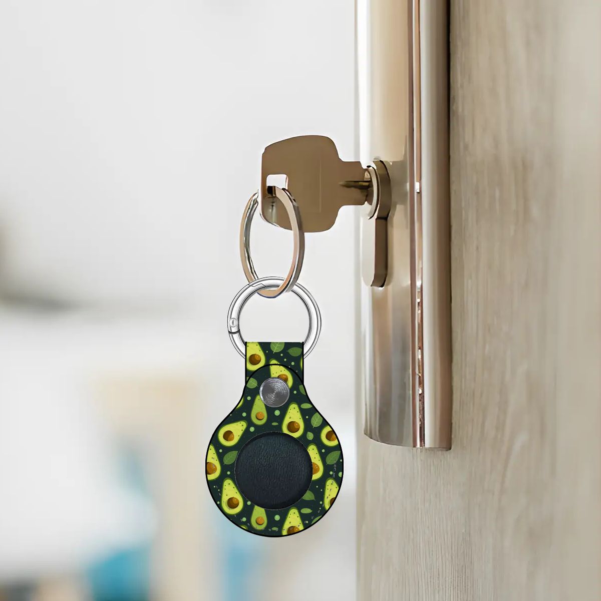 Avocado-patterned keychain attached to a door handle with a blurred background