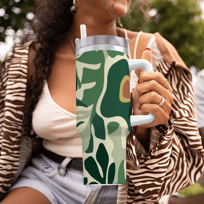 Person holding a green leaf-patterned tumbler outdoors