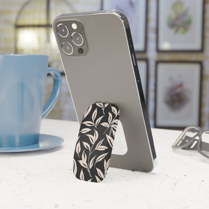 Phone with a floral stand on a table next to a blue mug
