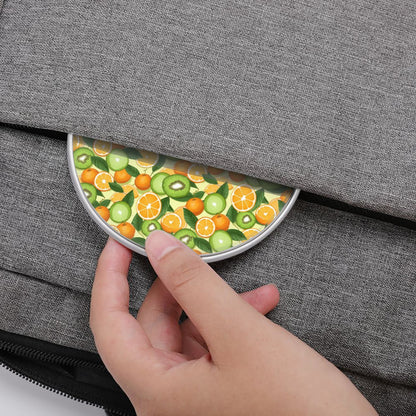 Hand placing a round fruit-patterned item into a gray bag