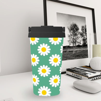 Tumbler with daisy pattern on a desk next to a framed picture and books.