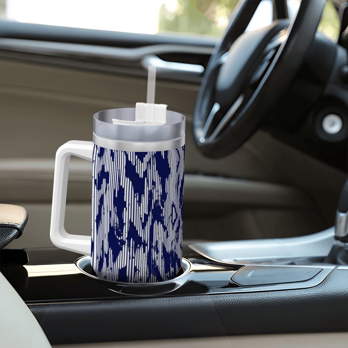 Blue and white patterned mug on a car cup holder with steering wheel and dashboard in the background