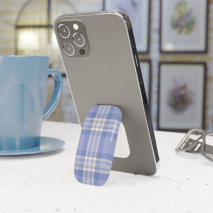 Phone with a blue plaid phone stand on a table next to a blue mug.