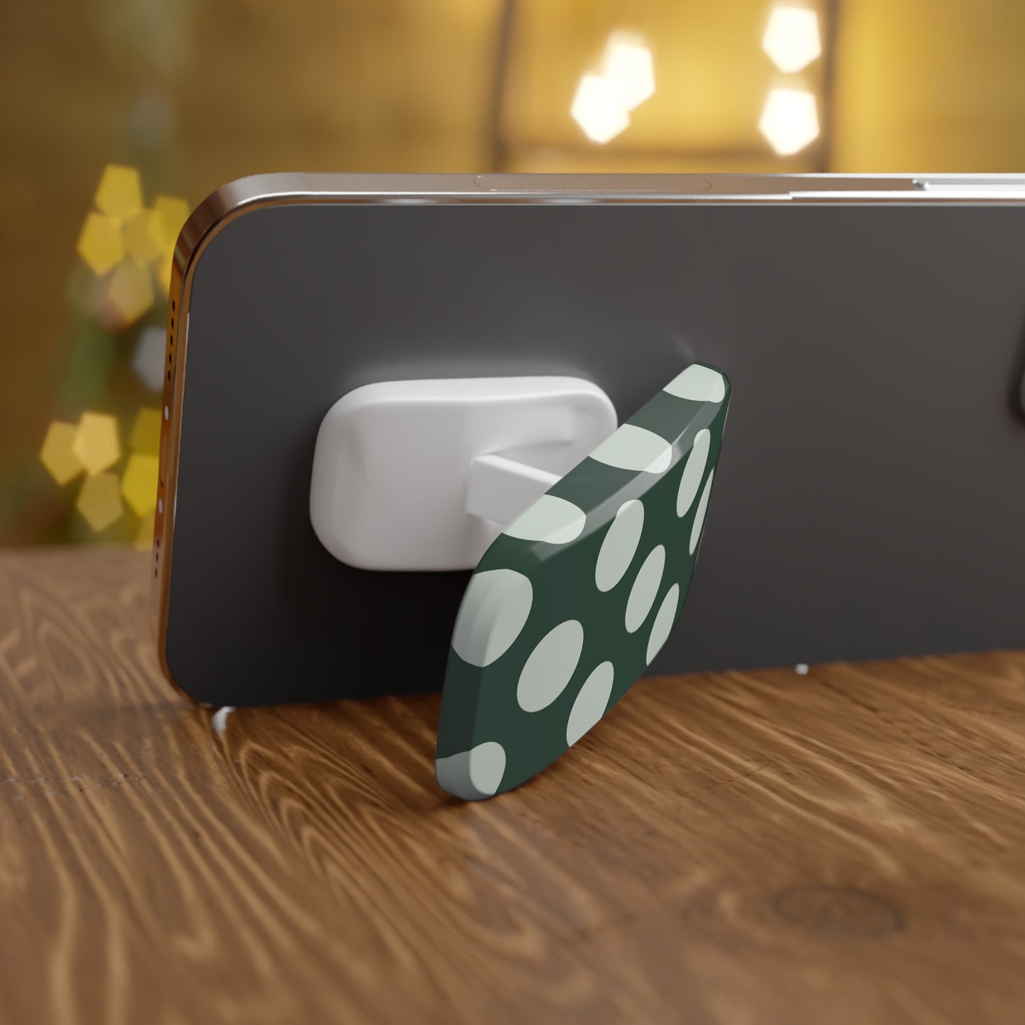 Phone holder with green and white polka dot design on a wooden surface