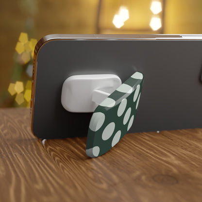 Phone holder with green and white polka dot design on a wooden surface