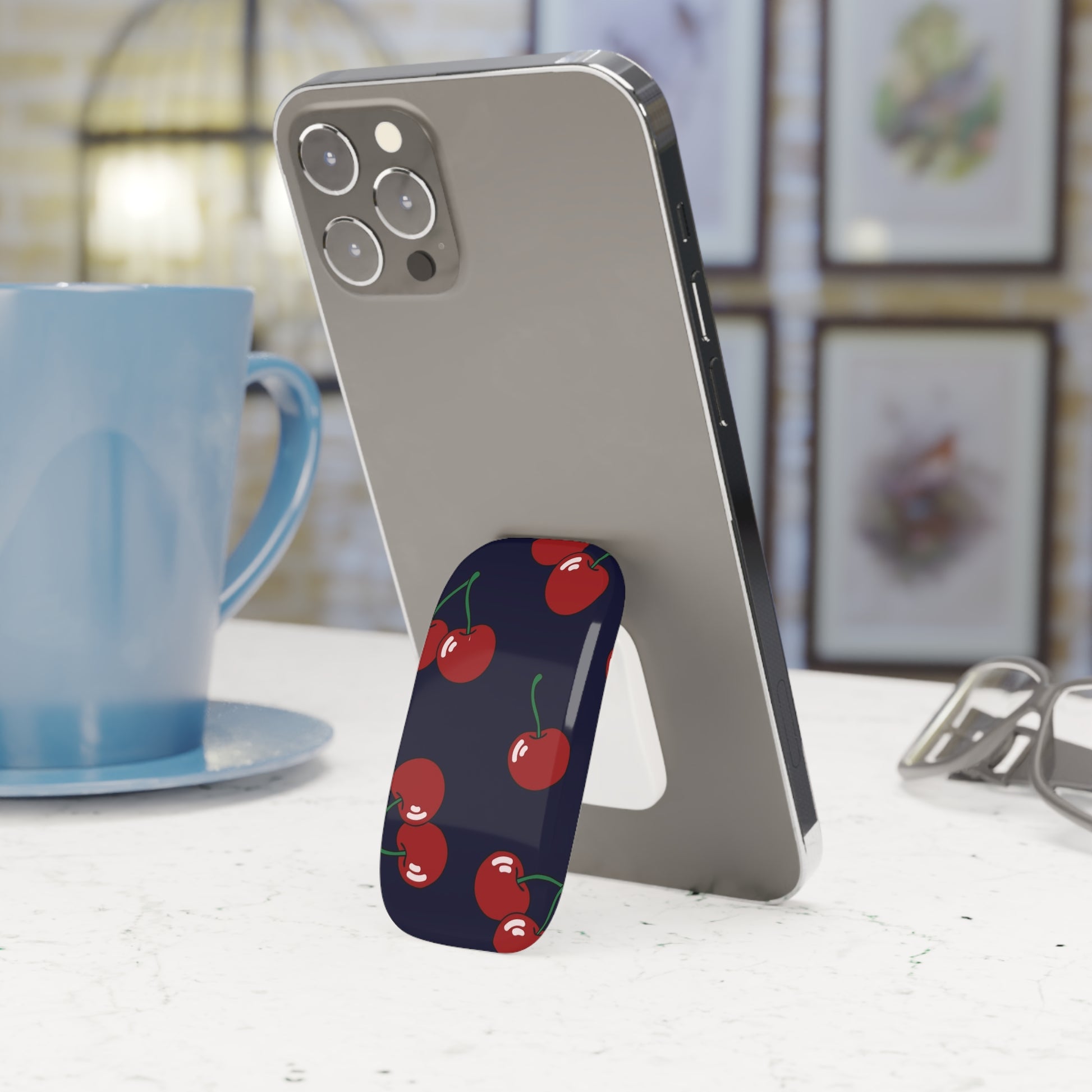 Phone stand with polka dot design on a table next to a blue mug