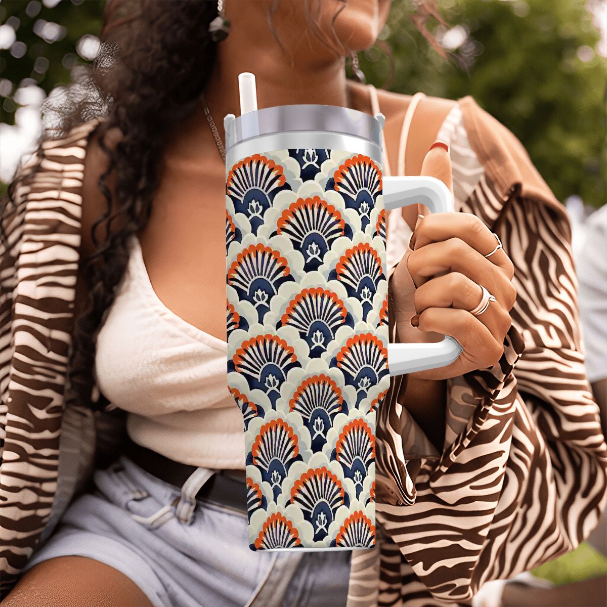 Person holding a patterned tumbler outdoors