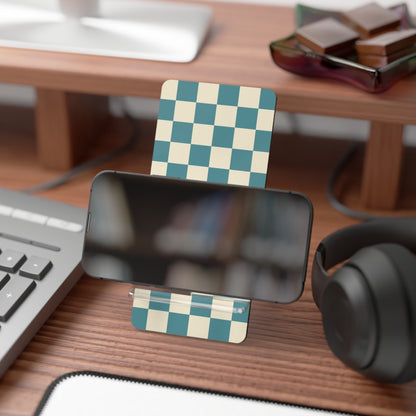 Desk setup with a smartphone stand, checkered card, keyboard, and headphones.