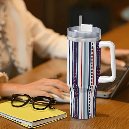 Striped mug with handle on a desk next to glasses and a notebook