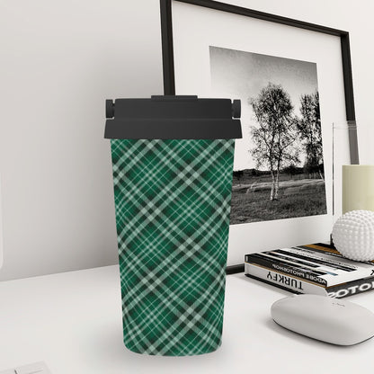 Green plaid tumbler with black lid on a desk next to a framed picture and books.