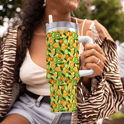 Person holding a colorful tumbler with fruit pattern outdoors