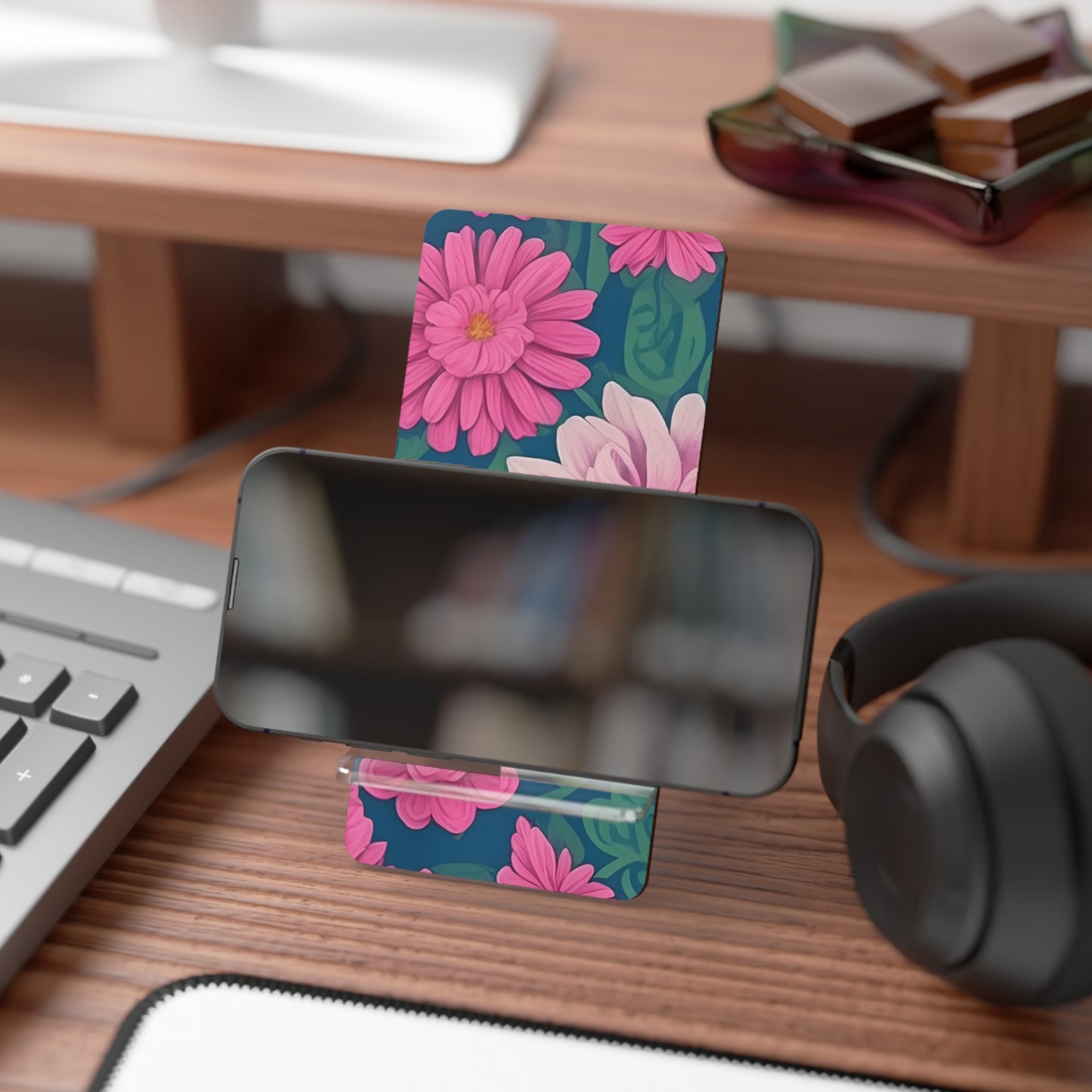 Floral phone stand on a desk with keyboard, mouse, and headphones