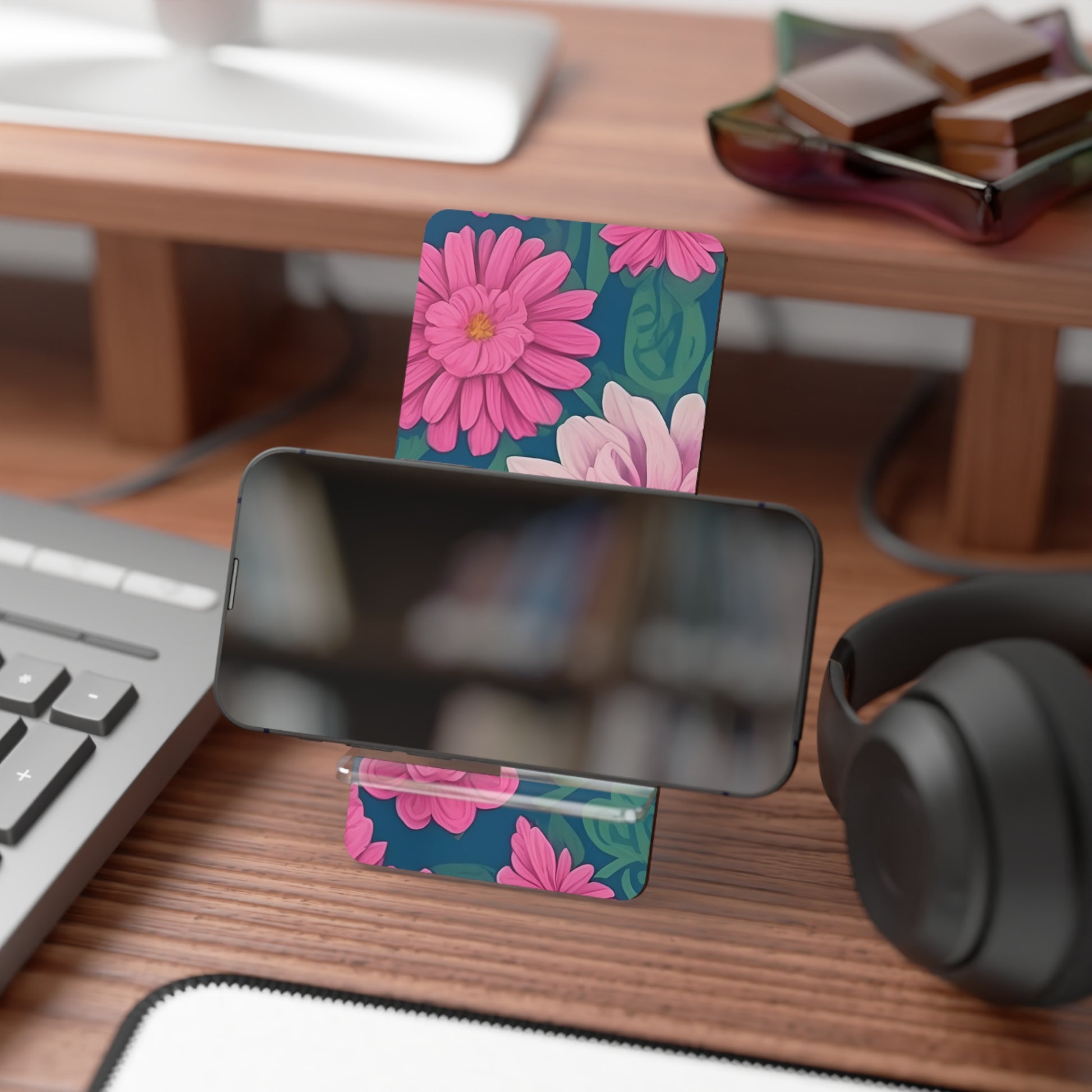 Floral phone stand on a desk with keyboard, mouse, and headphones