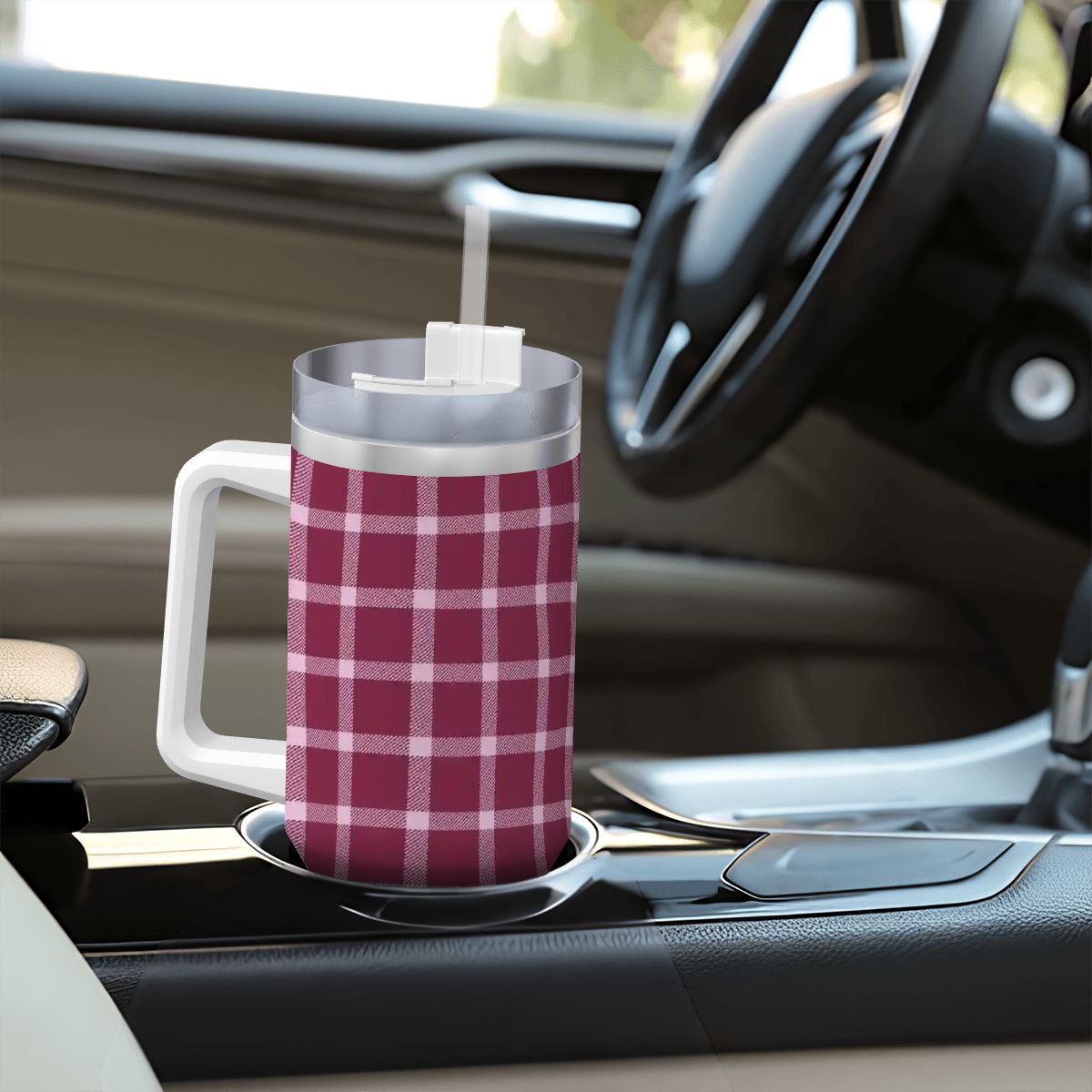 Plaid-patterned mug with straw on a car cup holder